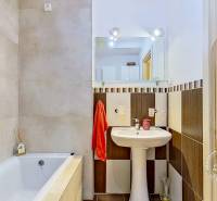 Koupelna v 3-pokojovém bytě s vanou, umyvadlem a zrcadlem.