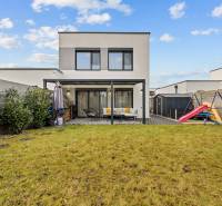 Zahrada 4pokojového bytu na Topolové ulici v Rovince s trávníkem a dětským hřištěm.