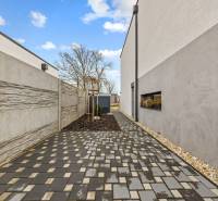 Dlázděná cesta podél domu na Topolové ulici v Rovince.