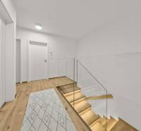 Chodba se schodištěm se skleněným zábradlím a podlahou s dřevěným dekorem ve 4pokojovém bytě.