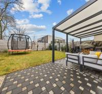 Zahrada u 4pokojového bytu na Topoľové ulici v Rovince s terasou a trampolínou.