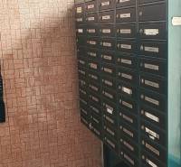 Schránky na chodbě 3pokojového bytu, stěna s cihlovým obkladem, podlahy s kamenným dekorem.