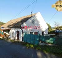 Obchodní prostory ve Vígľašské Huti-Kalince se sedlovou střechou a zpevněnou cestou.