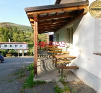 Dřevěná terasa obchodních prostor ve Vígľašské Hutě-Kalince, parkoviště, okolní příroda.