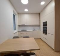 Kuchyně v 2pokojovém bytě s podlahou s dřevěným dekorem a jednoduchým zařízením.