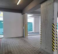 Parkovací místo s betonovými sloupy a osvětlením v Popradu.