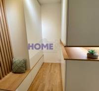 Útulný interiér 3-pokojového bytu s podlahou s dřevěným dekorem a vestavěným nábytkem.