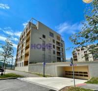 Bytový dům na ulici Zdenky Schelingové v Bratislavě, Devínské Nové Vsi, s garážovým vjezdem.