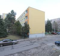 Bytový dům v Bratislavě na Cabanově ulici v prostředí s jehličnatými stromy.