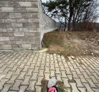 Zděný plot a betonová dlažba na pozemcích pro bydlení ve Velké Bytči.