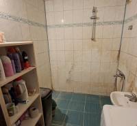 Útulná koupelna s pračkou, bílými obklady a poličkami, ideální pro 3pokojový byt.