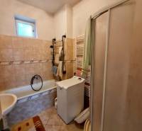 Koupelna s vanou, sprchovým koutem a pračkou v rodinném domě.