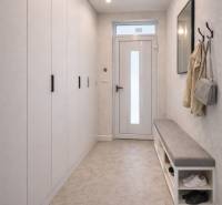 Chodba v rodinném domě s věšákem, lavicí a vestavěnou skříní.