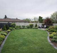 Udržovaná zahrada s terasou Rodinného domu ve Velkém Grobu, bohatá na zeleň a výsadbu.