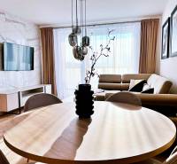 Obývací pokoj ve 3pokojovém bytě s podlahou s dřevěným dekorem a pohodlnou pohovkou.