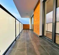 Bezpečné balkonové zábradlí a tmavá dlažba na balkóně 3pokojového bytu.