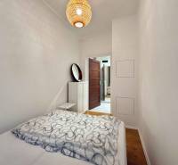 Ložnice s postelí a podlahou s dřevěným dekorem v 2-pokojovém bytě.