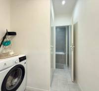 Pračka na chodbě 2pokojového bytu s přístupem do koupelny.