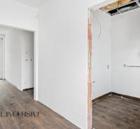 Interiér rodinného domu s podlahou s dřevěným dekorem a vytápěcím zařízením.