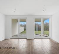 V rodinném domě je prostorná místnost s velkými okny a podlahou s dřevěným dekorem.