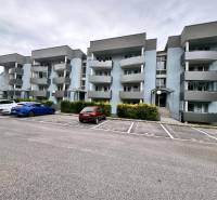 Bytový dům s šedými balkony na Halalovce v Trenčíně s parkovacími místy.