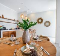 Prostřený stůl ve vile s podlahou s dřevěným dekorem a kuchyňským koutem.