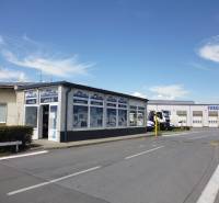 Budova s garážemi a nákladními vozidly na Strojnícké ulici v Prešově, sklady a haly.