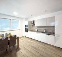 Kuchyně v 3-pokojovém bytě s moderní linkou a podlahou s dřevěným dekorem.