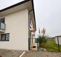 Exteriér 3-pokojového bytu na ulici Kráľovianky ve městě Kráľovianky, u vchodu rostliny a trávník.