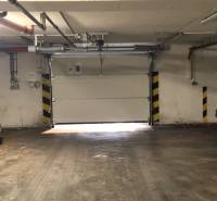 Budova garáže s betonovou podlahou a garážovými vraty.