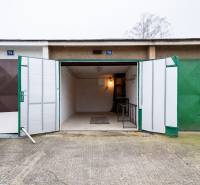 Otevřená garáž na Inovecké ulici v Trenčíně s vnitřním osvětlením a poličkami.