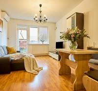 Obývací pokoj v 2pokojovém bytě s podlahou s dřevěným dekorem a pohovkou.