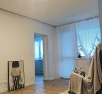 Interiér 4-pokojového bytu s podlahou s dřevěným dekorem a světelným stropním prvkem.