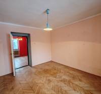 Pokoj v 2-pokojovém bytě s podlahou s dřevěným dekorem a jednoduchým osvětlením.