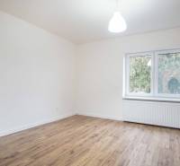 Pokoj v rodinném domě s elektrickými zásuvkami a podlahou s dřevěným dekorem.