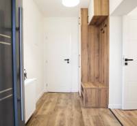 Interiér rodinného domu s podlahou s dřevěným dekorem a vestavěným nábytkem.