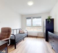 Pokoj s podlahou s dřevěným dekorem, pracovním stolem a pohovkou ve 3-pokojovém bytě.