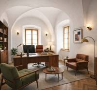 Interiér budovy s pohodlným nábytkem a podlahou s dřevěným dekorem.