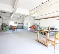 Průmyslový interiér budovy s pracovním stolem a židlemi.