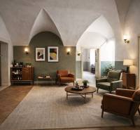 Interiér budovy s podlahou s dřevěným dekorem, pohodlným nábytkem a dekorativními prvky.