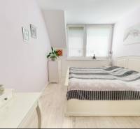 Ložnice v rodinném domě s dekorem dřevěné podlahy a světlým nábytkem.