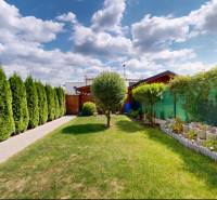 Zahrada rodinného domu ve Stupavě s udržovaným trávníkem a výsadbou.