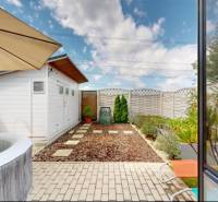 Zahrada rodinného domu ve Stupavě s vířivkou a zahradním domkem.