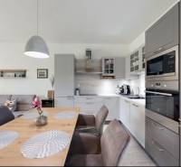 Interiér rodinného domu s kuchyní, jídelním stolem a obývacím pokojem.