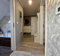 Koupelna v 2-pokojovém bytě s podlahou s dřevěným dekorem a světlými stěnami.