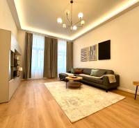 Obývací pokoj dvoupokojového bytu s podlahou s dřevěným dekorem a stylovým osvětlením.