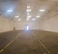 Prostorné sklady a haly s bílými stěnami, rovnou podlahou a osvětlením shora.