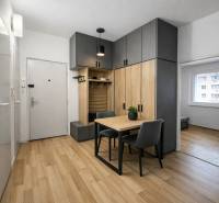 Předsíň 3pokojového bytu s podlahou s dřevěným dekorem a vestavěnými skříněmi.