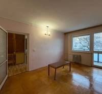 3-pokojový byt s podlahou s dřevěným dekorem, stůl, balkónové dveře.