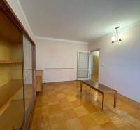 Obývací pokoj v 3-pokojovém bytě s podlahou s dřevěným dekorem a nábytkem.